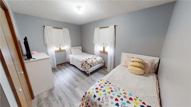 bedroom featuring light wood-style floors and a textured ceiling