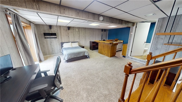 bedroom with carpet flooring, a paneled ceiling, and wooden walls