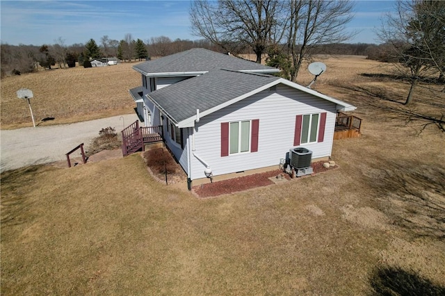 view of side of home with a yard, a shingled roof, crawl space, and central air condition unit