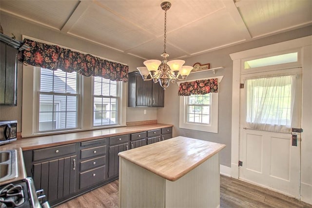 1470 W Decatur St, Decatur, IL 62522 - kitchen with wood finished floors, a chandelier, stainless steel microwave, a kitchen island, and decorative light fixtures