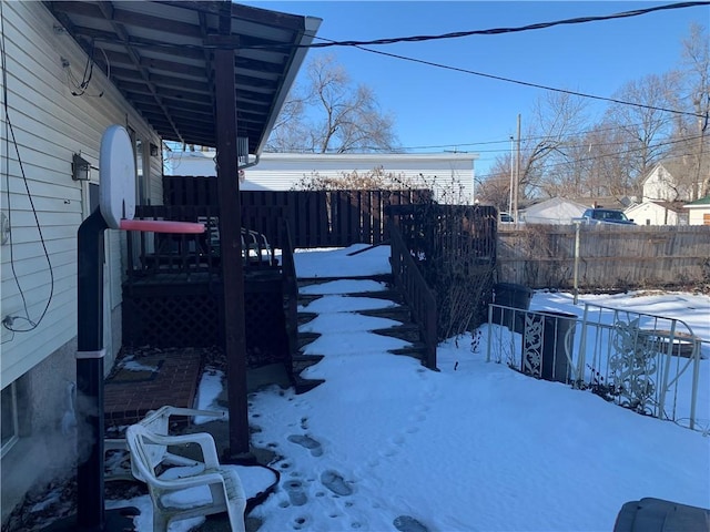 yard covered in snow featuring fence