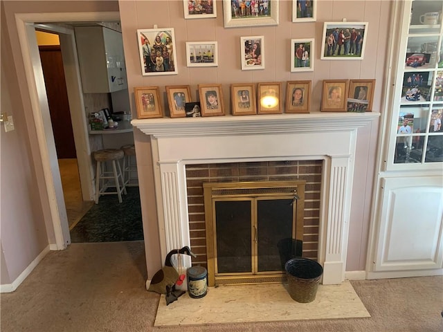 room details featuring carpet floors, a brick fireplace, and baseboards