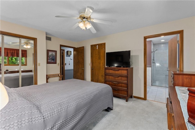 bedroom featuring light colored carpet, ceiling fan, and ensuite bathroom