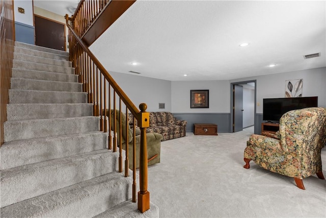 carpeted living area featuring stairway and recessed lighting