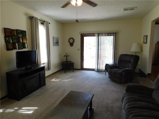 205 Monroe St, Toledo, IL 62468 - carpeted living area featuring a textured ceiling, ceiling fan, and plenty of natural light