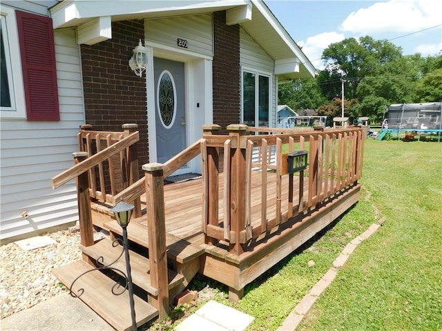 205 Monroe St, Toledo, IL 62468 - wooden deck featuring a trampoline and a yard