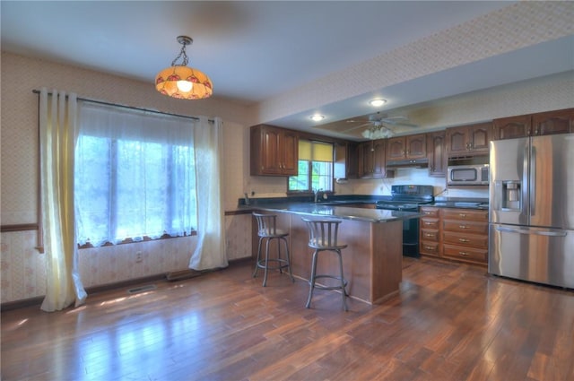 1225 W Pineview Ct, Decatur, IL 62526 - kitchen with appliances with stainless steel finishes, wallpapered walls, dark wood-style floors, a peninsula, and dark countertops