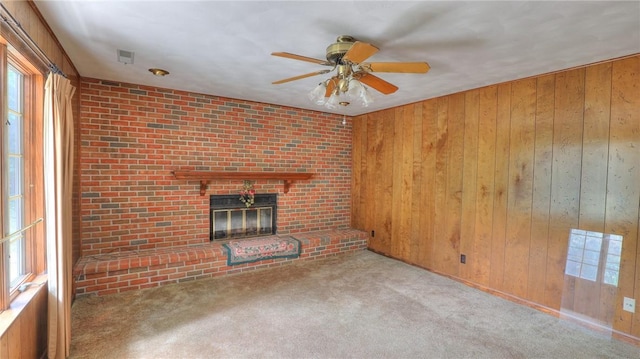1225 W Pineview Ct, Decatur, IL 62526 - unfurnished living room featuring a ceiling fan, healthy amount of natural light, wood walls, carpet floors, and a fireplace