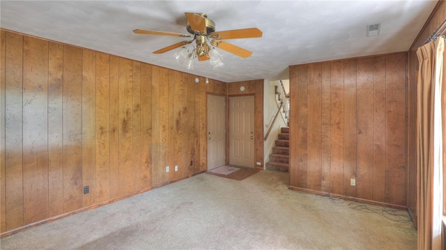 1225 W Pineview Ct, Decatur, IL 62526 - carpeted spare room with wooden walls, a ceiling fan, and stairway
