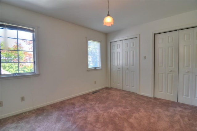 1225 W Pineview Ct, Decatur, IL 62526 - unfurnished bedroom featuring multiple closets and carpet flooring