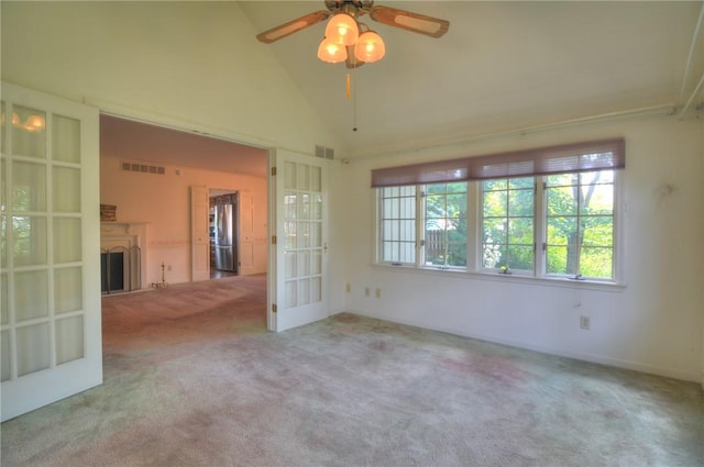 1225 W Pineview Ct, Decatur, IL 62526 - empty room featuring carpet, french doors, a ceiling fan, vaulted ceiling, and a fireplace