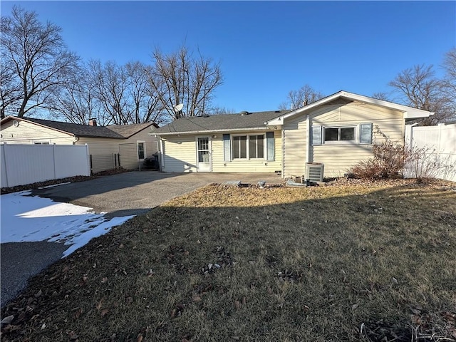 back of house with a patio, central air condition unit, fence, driveway, and a lawn