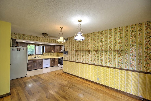 3103 N Oakland Ave, Decatur, IL 62526 - kitchen with white appliances, wallpapered walls, light wood-style floors, a sink, and light countertops
