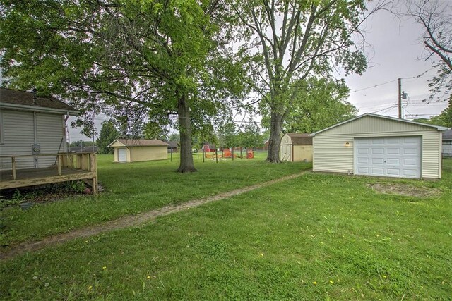 3103 N Oakland Ave, Decatur, IL 62526 - view of green lawn with an outdoor structure, a garage, driveway, and a deck