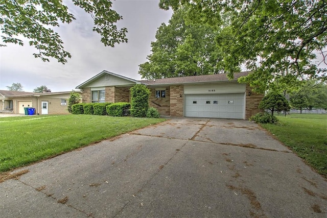 3103 N Oakland Ave, Decatur, IL 62526 - view of front of house with brick siding, a garage, driveway, and a front yard