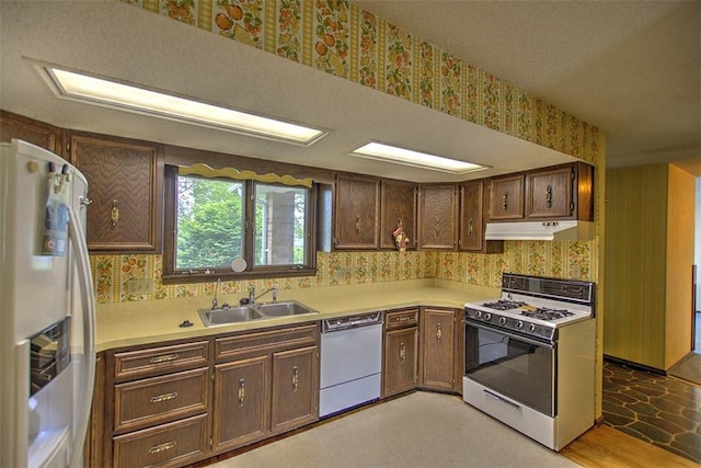 3103 N Oakland Ave, Decatur, IL 62526 - kitchen with white appliances, wallpapered walls, a sink, under cabinet range hood, and light countertops