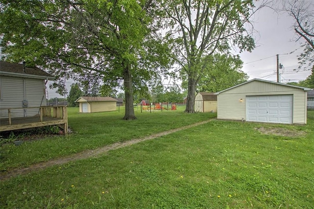 3103 N Oakland Ave, Decatur, IL 62526 - view of green lawn with an outdoor structure, a garage, driveway, and a deck