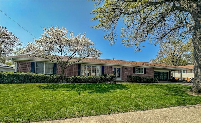 ranch-style home featuring an attached garage, a front lawn, and brick siding