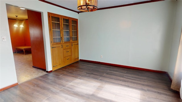 29 Peckerwood Ct, Bethany, IL 61914 - empty room with baseboards, ornamental molding, dark wood-style flooring, and a notable chandelier