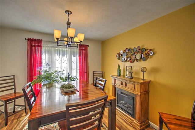 940 Kirk Dr, Mt Zion, IL 62549 - dining space with a chandelier, wood finished floors, and a fireplace