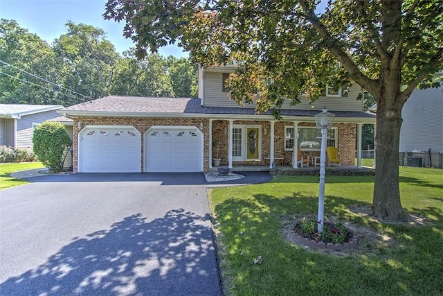 940 Kirk Dr, Mt Zion, IL 62549 - view of front of property with asphalt driveway, an attached garage, a front yard, a porch, and brick siding