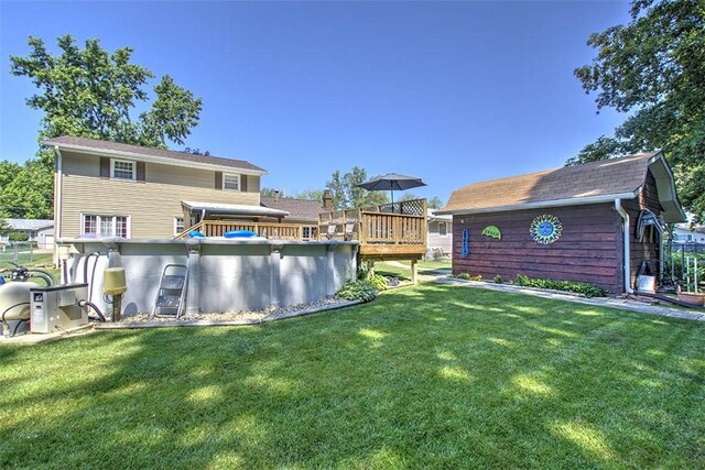 940 Kirk Dr, Mt Zion, IL 62549 - rear view of property featuring a lawn, a deck, and an outbuilding