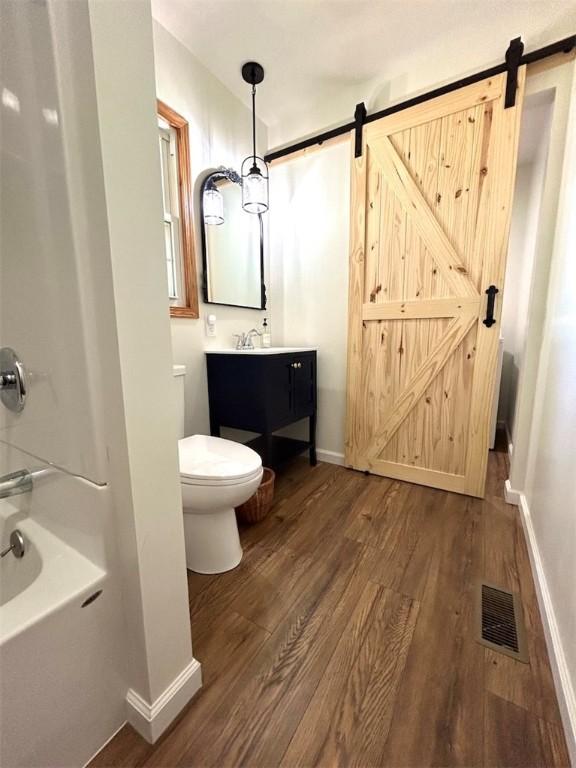 20786 Heritage Ln, Marshall, IL 62441 - full bathroom featuring visible vents, baseboards, toilet, vanity, and wood finished floors