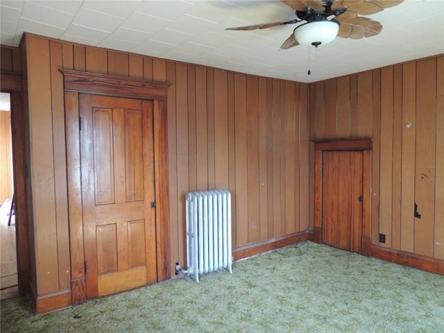 401 3rd St, Altamont, IL 62411 - unfurnished room with radiator, carpet flooring, a ceiling fan, and wood walls