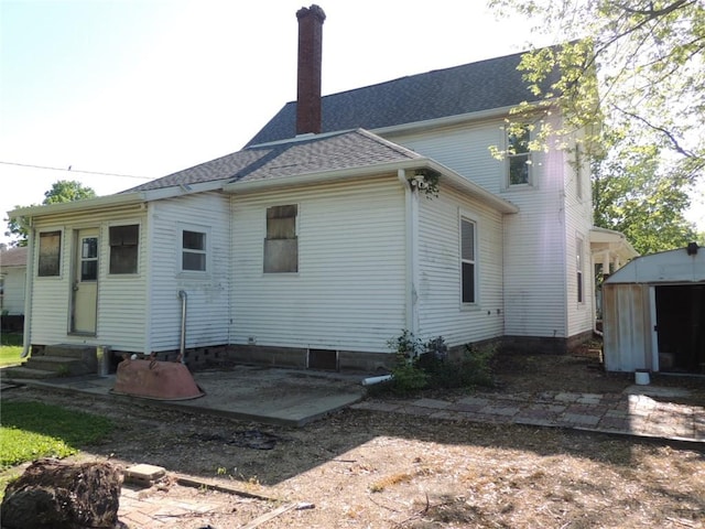 401 3rd St, Altamont, IL 62411 - rear view of house featuring entry steps, a chimney, and a shingled roof