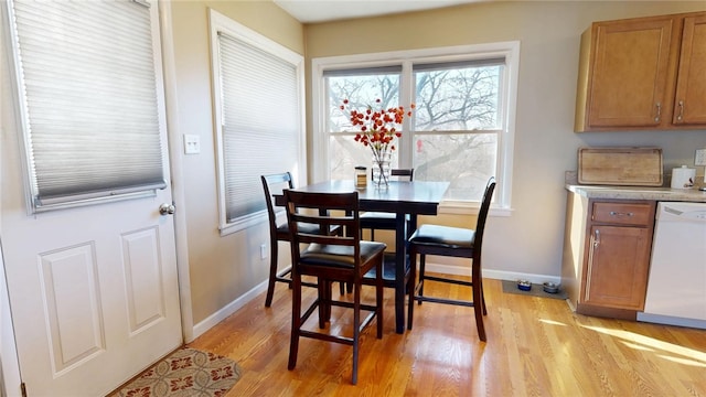 dining area with light wood-style flooring and baseboards