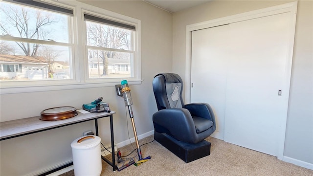 living area featuring carpet flooring and baseboards