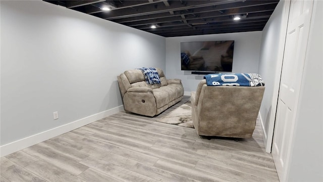 living area with baseboards and wood finished floors