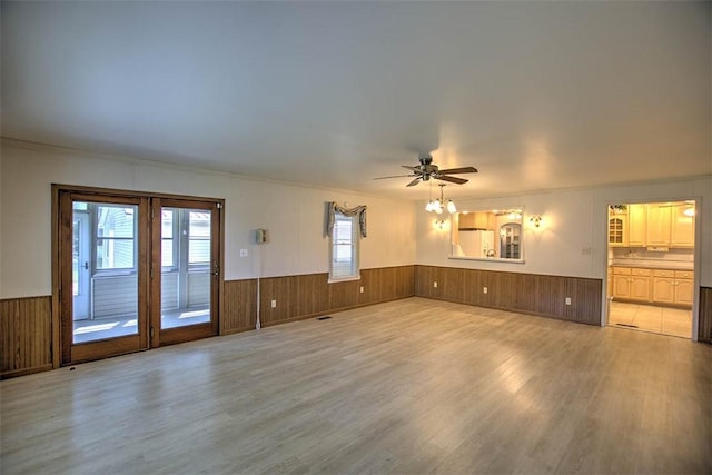 3204 Meadow Ln, Decatur, IL 62521 - unfurnished living room featuring wainscoting, wood finished floors, a ceiling fan, ornamental molding, and wooden walls
