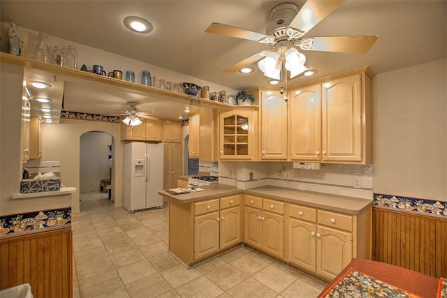 3204 Meadow Ln, Decatur, IL 62521 - kitchen featuring white fridge with ice dispenser, a ceiling fan, arched walkways, glass insert cabinets, and a peninsula