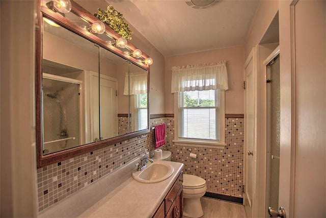 3204 Meadow Ln, Decatur, IL 62521 - bathroom with a stall shower, vanity, a wainscoted wall, tile walls, and wood finished floors