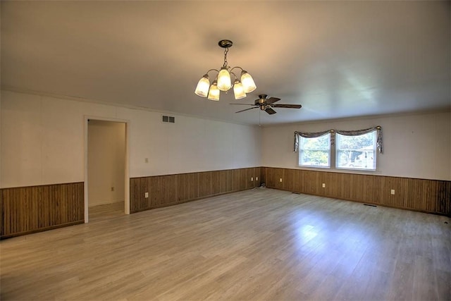 3204 Meadow Ln, Decatur, IL 62521 - unfurnished room featuring a wainscoted wall, light wood-type flooring, a chandelier, a ceiling fan, and wood walls