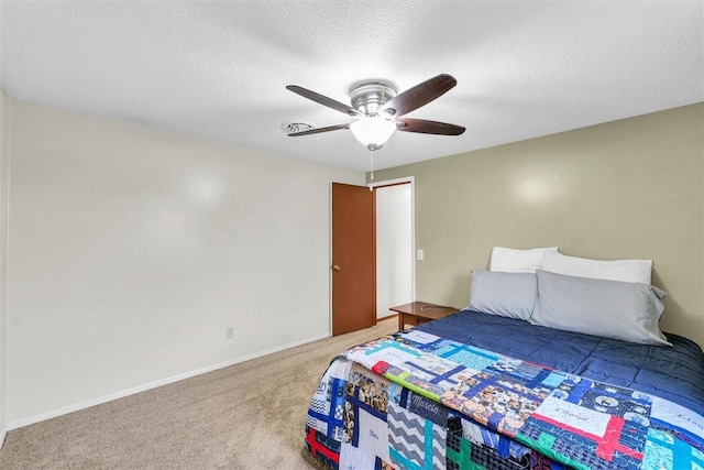 carpeted bedroom with a ceiling fan, baseboards, and a textured ceiling