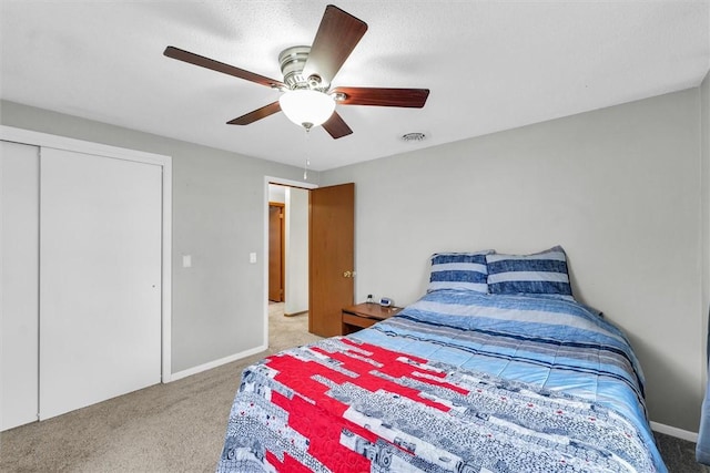 bedroom with light carpet, visible vents, baseboards, ceiling fan, and a closet