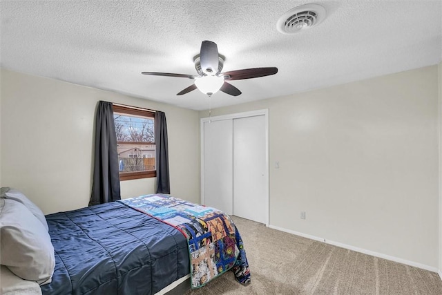 bedroom with baseboards, visible vents, a ceiling fan, carpet floors, and a closet