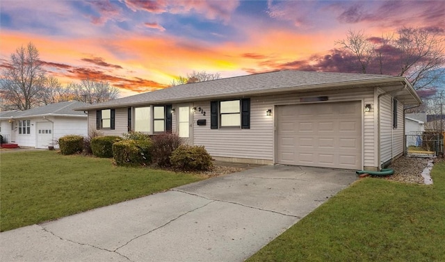 ranch-style home with roof with shingles, a yard, an attached garage, fence, and driveway