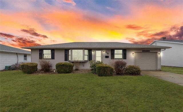 ranch-style home featuring a garage, concrete driveway, and a front lawn