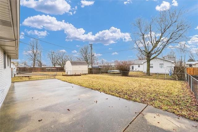 view of yard featuring an outbuilding, a patio area, and a fenced backyard