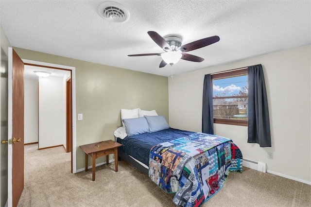 bedroom featuring visible vents, baseboard heating, a textured ceiling, and light colored carpet