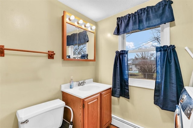 bathroom featuring a baseboard heating unit, vanity, and toilet