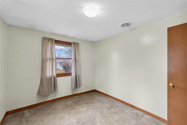 empty room featuring baseboards, a textured ceiling, visible vents, and carpet flooring