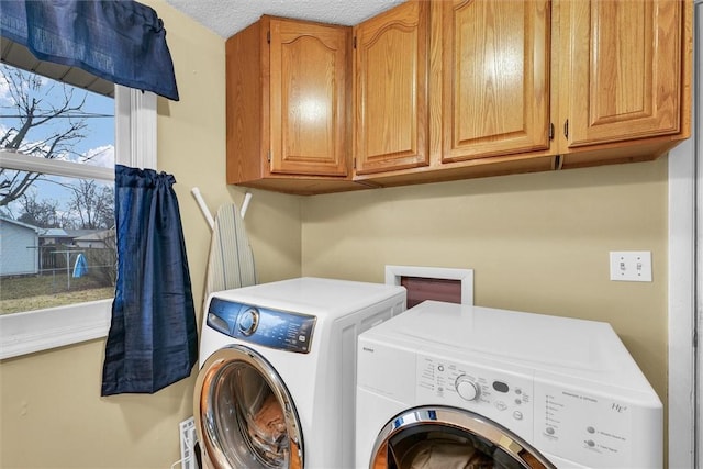 washroom featuring cabinet space, independent washer and dryer, and a textured ceiling