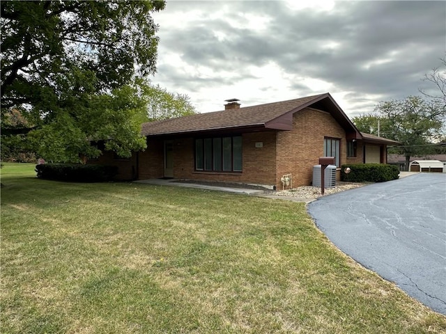 view of side of property featuring a yard and cooling unit