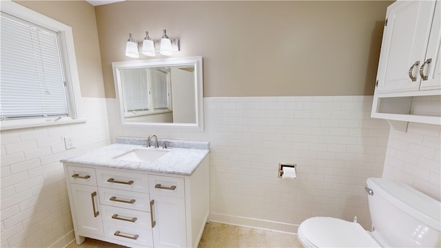 bathroom featuring tile walls, vanity, tile patterned flooring, and toilet