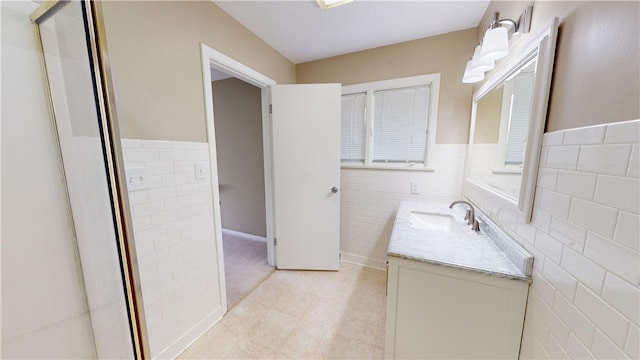 bathroom featuring vanity and tile walls