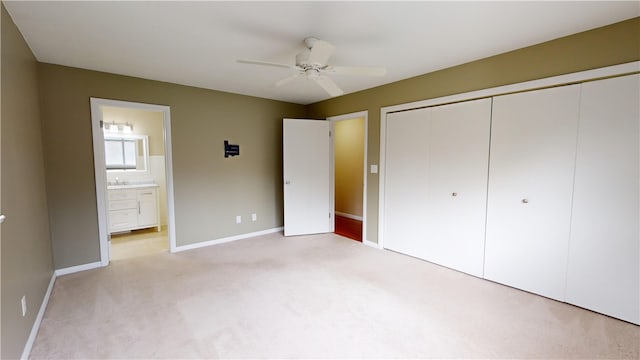 unfurnished bedroom with ensuite bathroom, light carpet, ceiling fan, and a closet